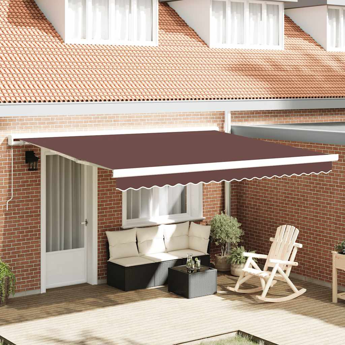 Eine braune Markise bedeckt eine Terrasse mit Sitzbereich, Schaukelstuhl und Topfpflanzen an einer Ziegelmauer.
