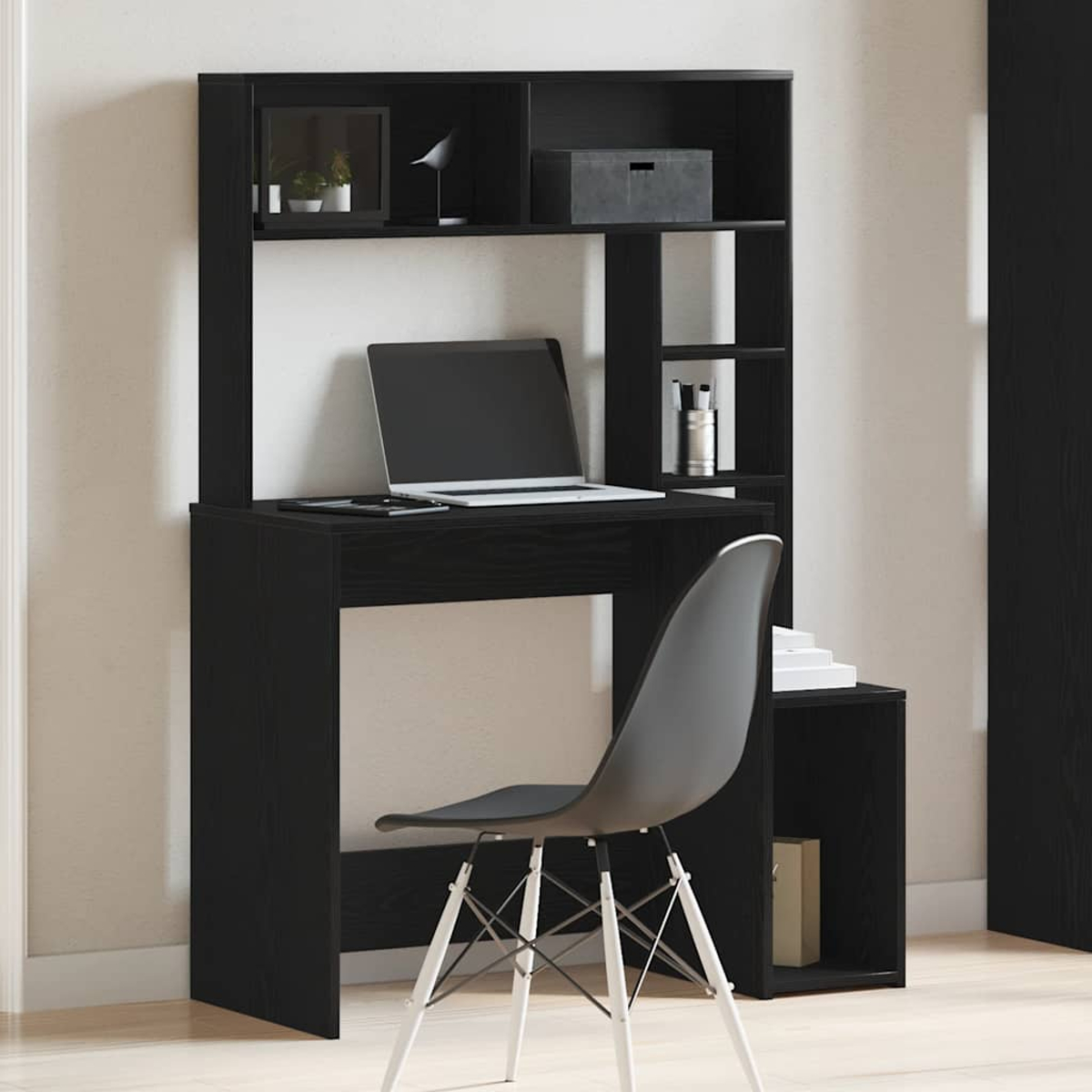 Schwarzer Schreibtisch mit Regalen, Laptop und Stuhl. Der Schreibtisch hat ein eingebautes Regal. Vor dem Schreibtisch steht ein Stuhl.