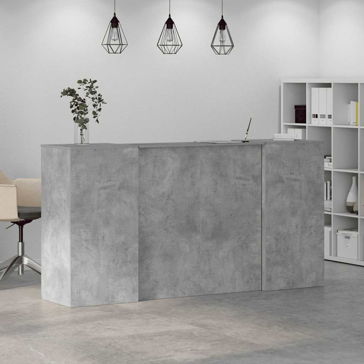 Ein grauer Empfangstresen aus Beton mit einer Vase mit Pflanzen, drei Hängelampen und einem weißen Bücherregal im Hintergrund.