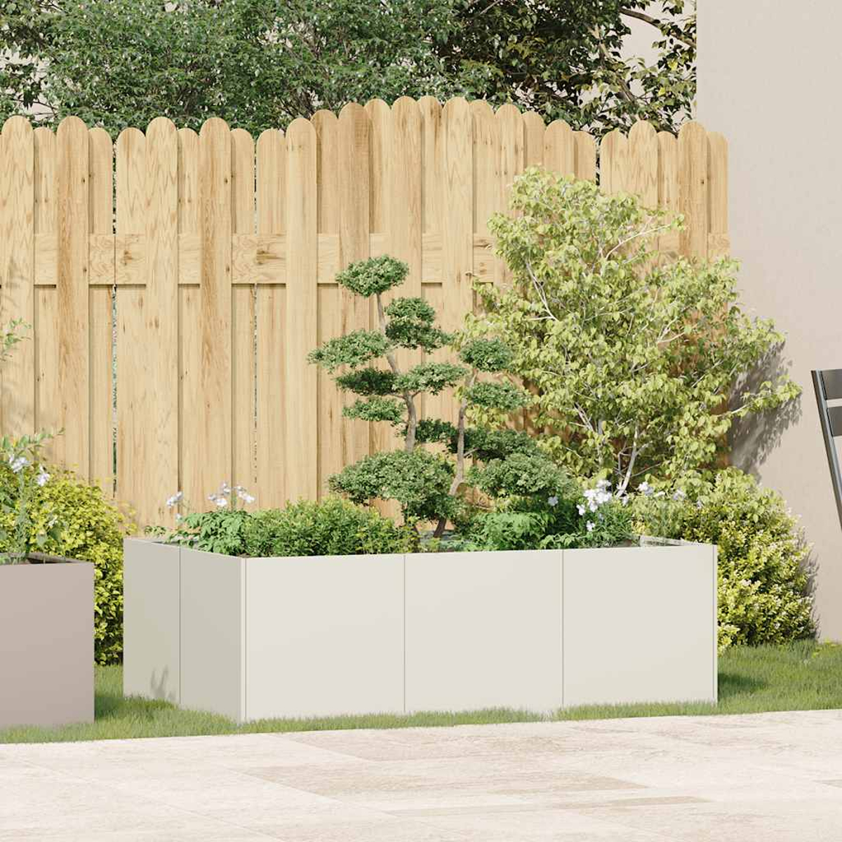 Una fioriera rettangolare con piante verdi e un bonsai si trova sull'erba. Sullo sfondo c'è una staccionata di legno.