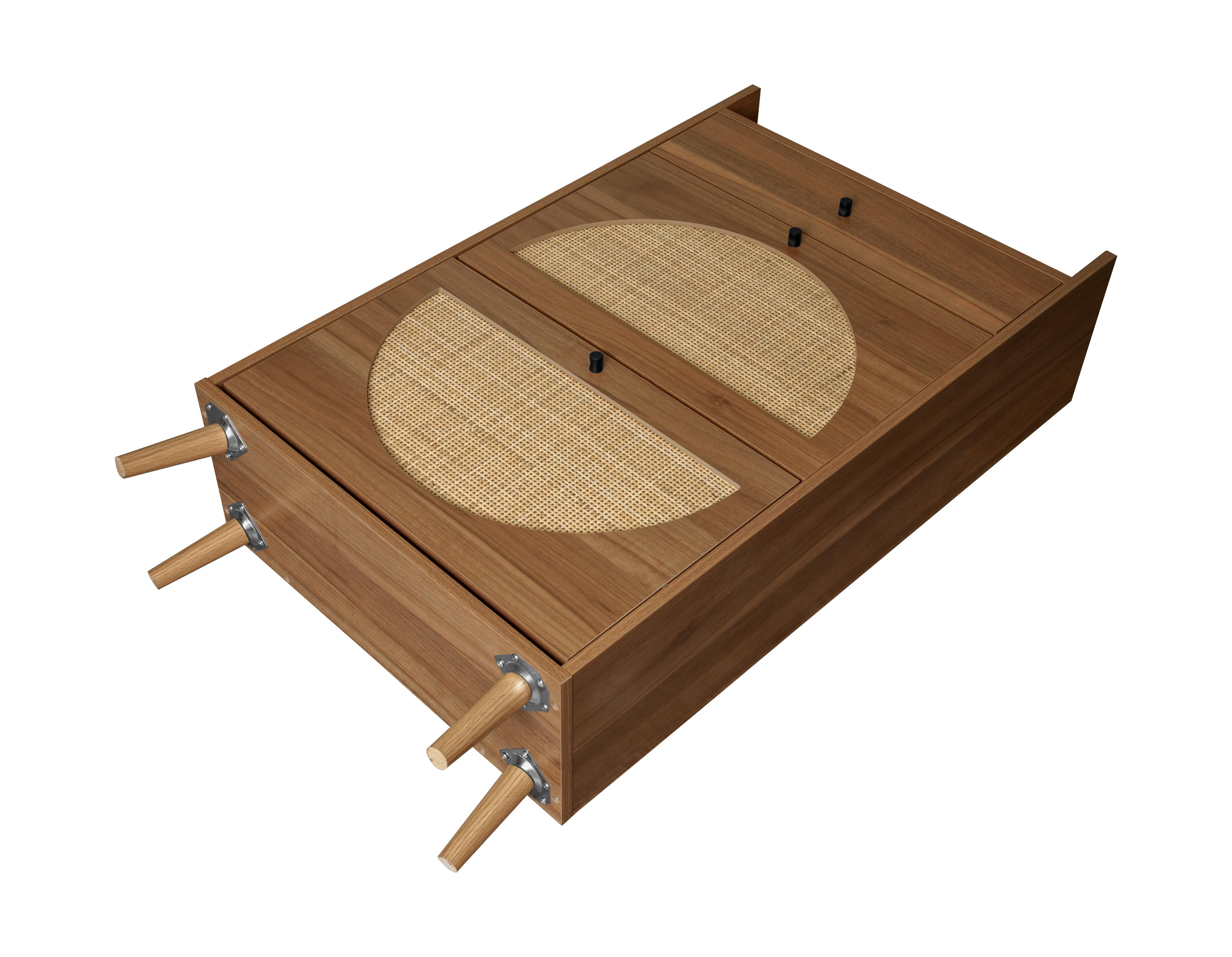 Holzschrank mit gewebten Einsätzen. Er hat zwei Türen mit schwarzen Knöpfen und Holzbeinen.