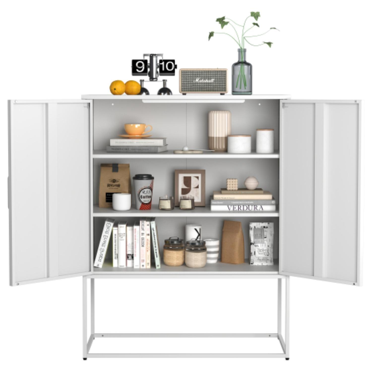 Weißer Schrank mit offenen Türen. Er hat Regale mit Büchern, Kaffeetassen, Dekorationen und einer Uhr. Oben liegen Orangen und eine Pflanze.