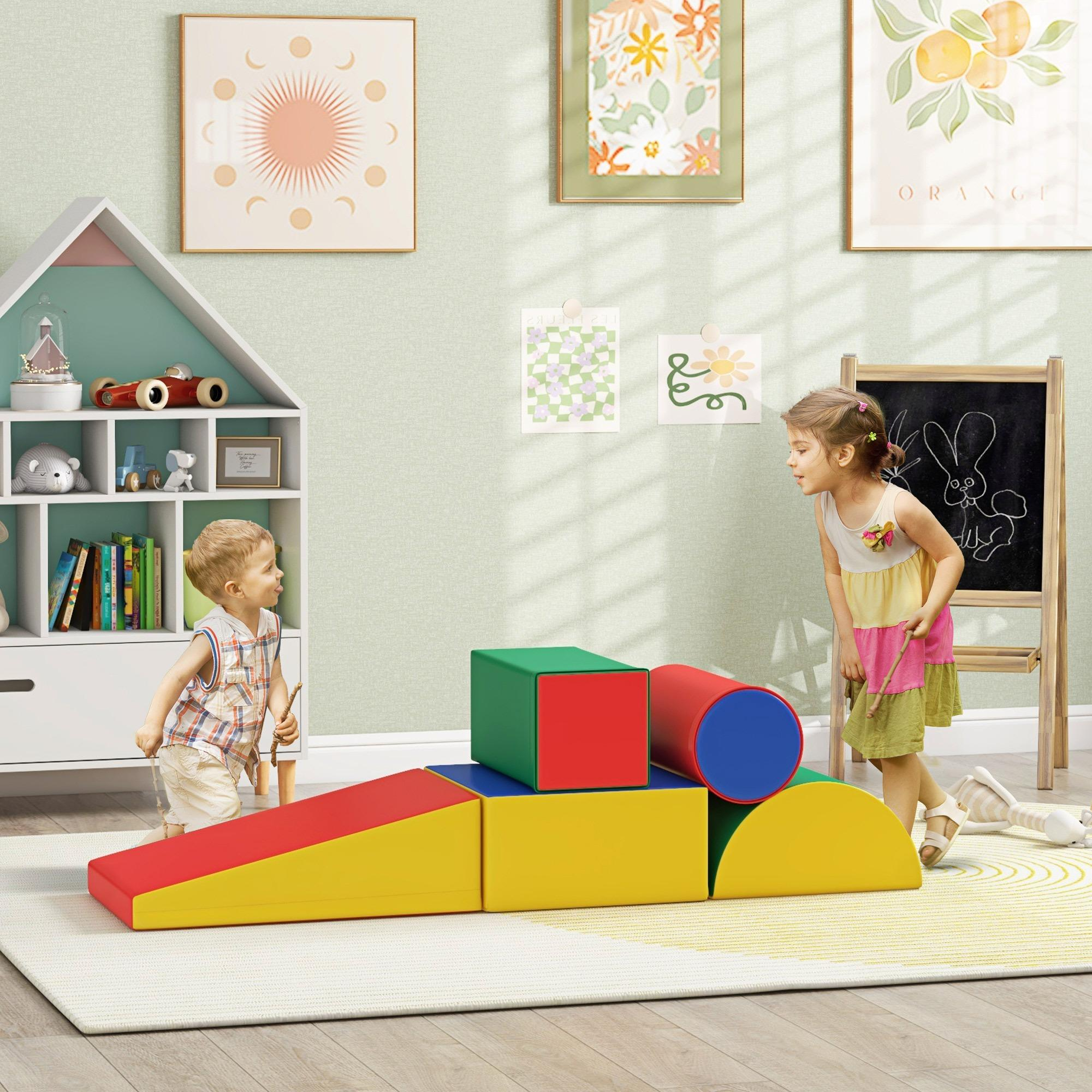 Zwei Kinder spielen in der Nähe von bunten Schaumstoffblöcken und einer Tafel. Kunstwerke und ein weißes Regal sind im Hintergrund.