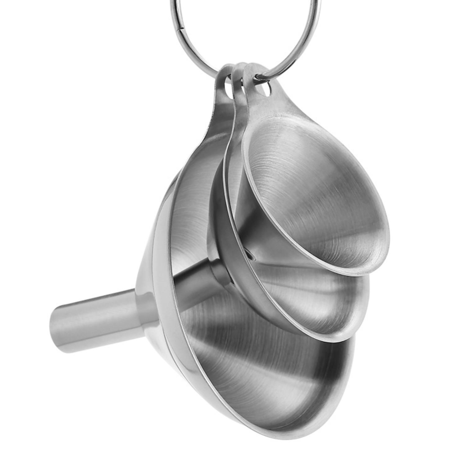 Drei Trichter aus Edelstahl hängen an einem Ring. Die Trichter sind ineinander verschachtelt und zeigen ihre unterschiedlichen Größen. Weißer Hintergrund.