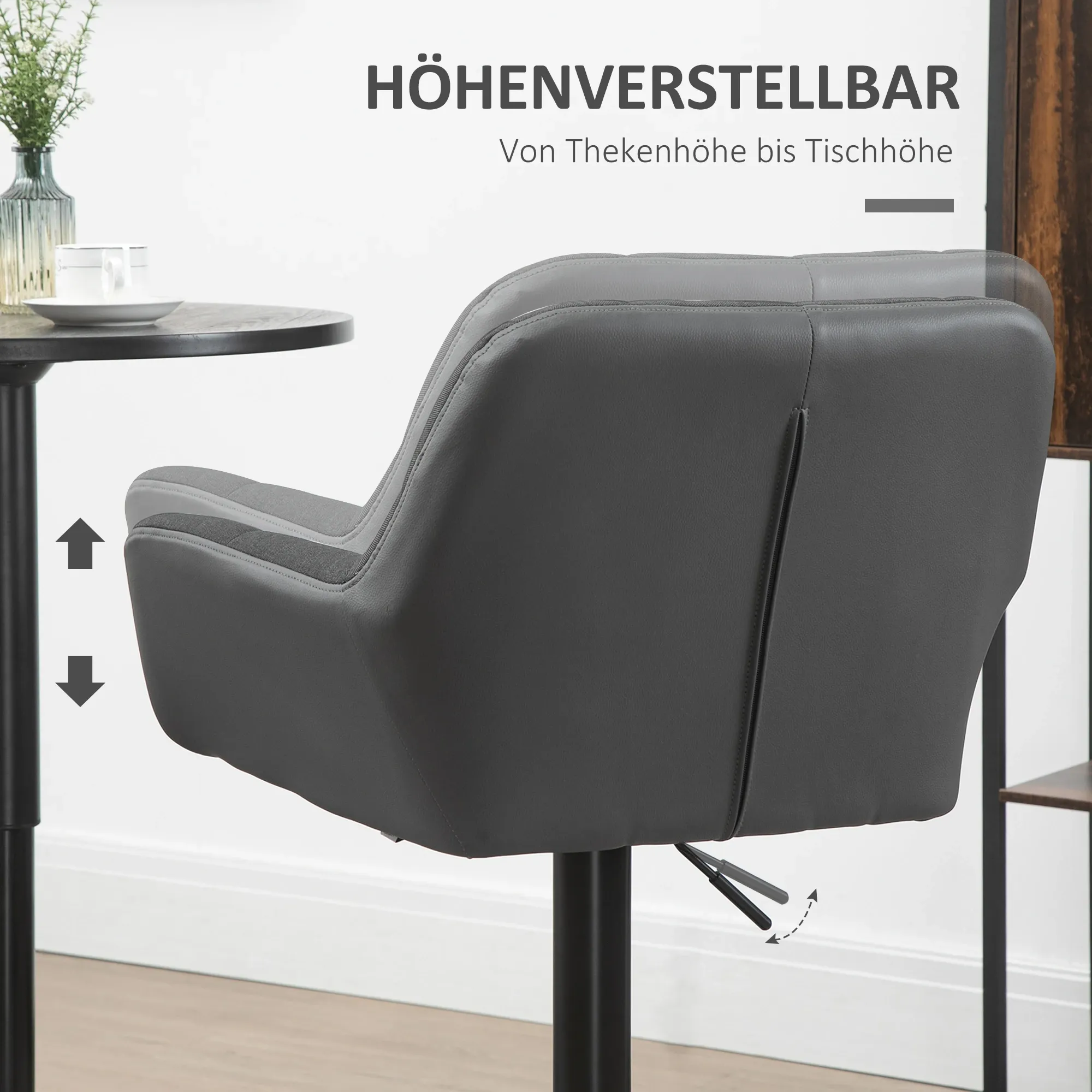 Ein grauer, verstellbarer Stuhl wird gezeigt. Er steht neben einem kleinen Tisch mit einer Tasse und Blumen.