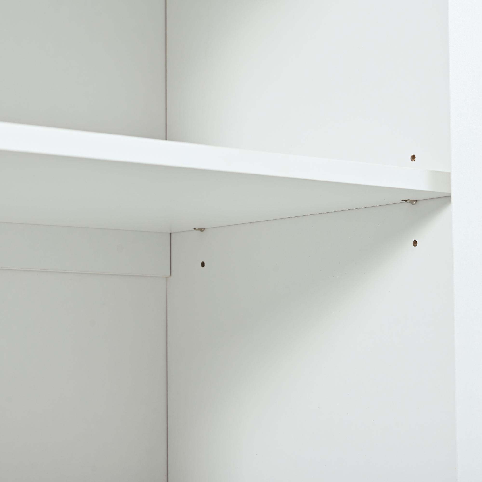 Im Inneren eines weißen Schranks. Sichtbar sind Regale, Wände und ein paar Schraubenlöcher. Die Szene ist beleuchtet, mit Schatten.