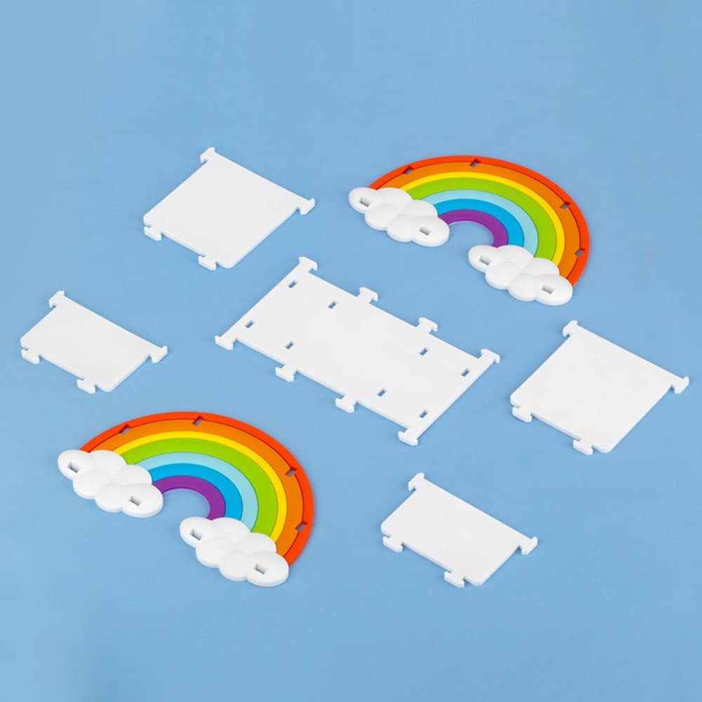 Das Bild zeigt bunte Regenbogenformen mit weißen Wolkendetails und weißen rechteckigen Teilen, alles auf blauem Hintergrund.