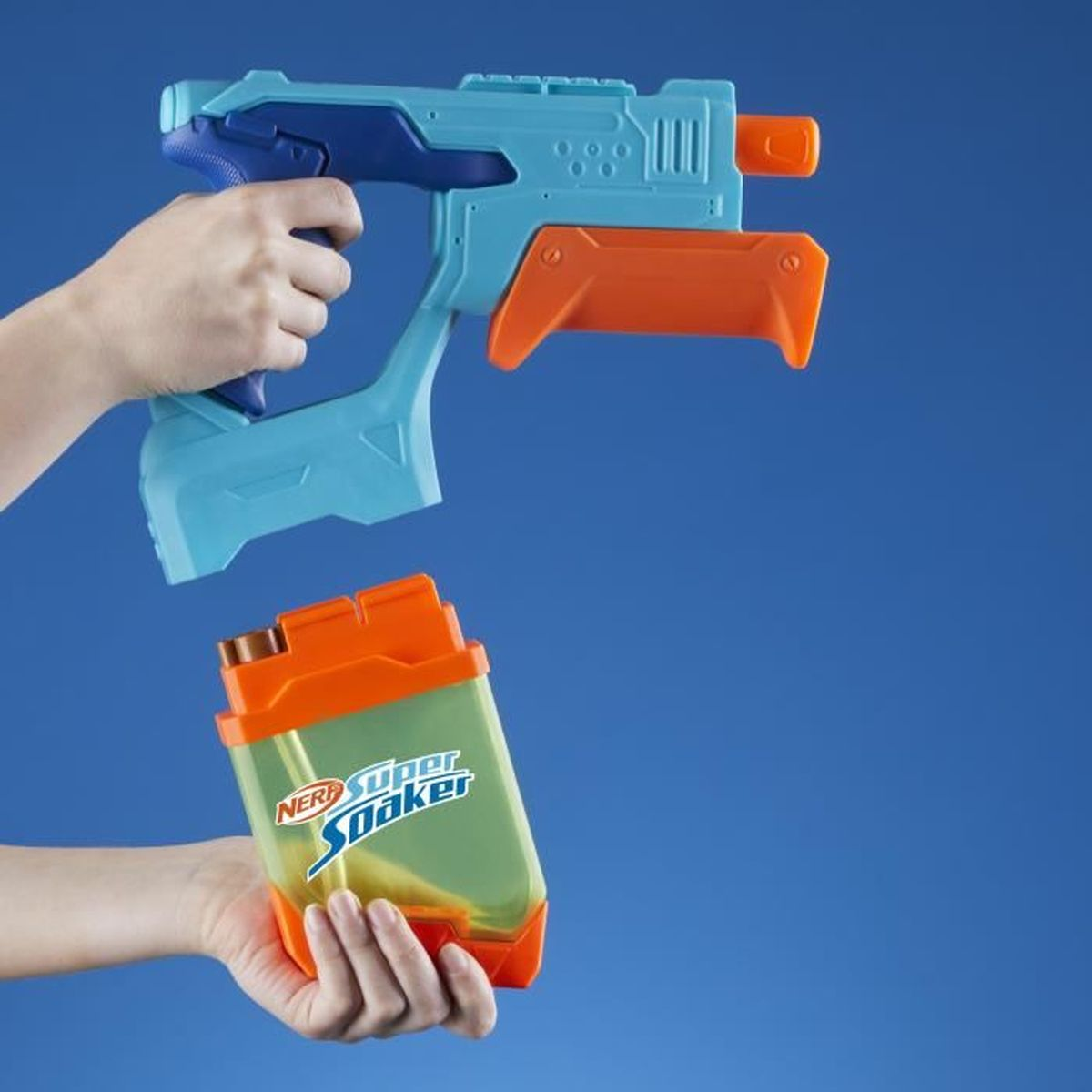 Eine Person hält eine blau-orangefarbene Nerf Super Soaker Wasserpistole und ihr orangefarbenes Wasserreservoir vor blauem Hintergrund.