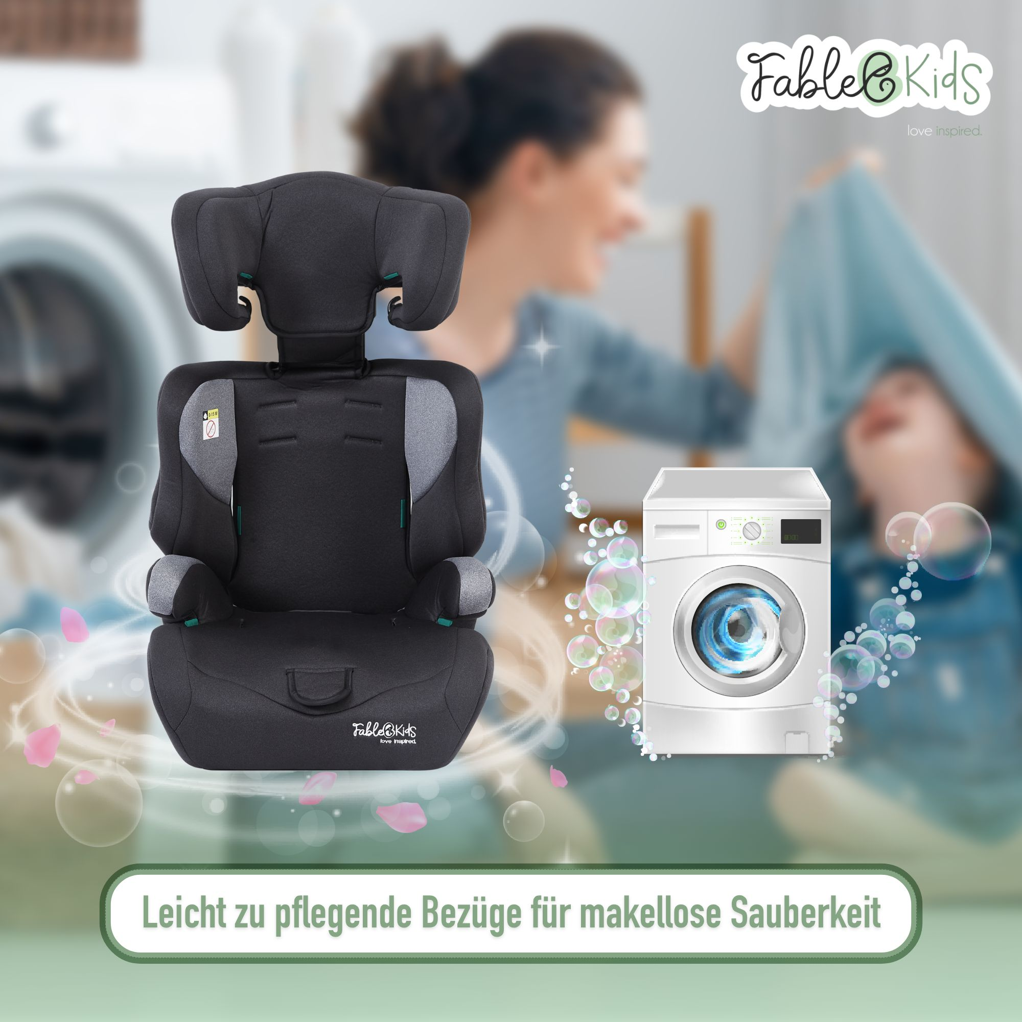 Ein Kindersitz im Vordergrund. Waschmaschine und Frau mit Kind im Hintergrund.