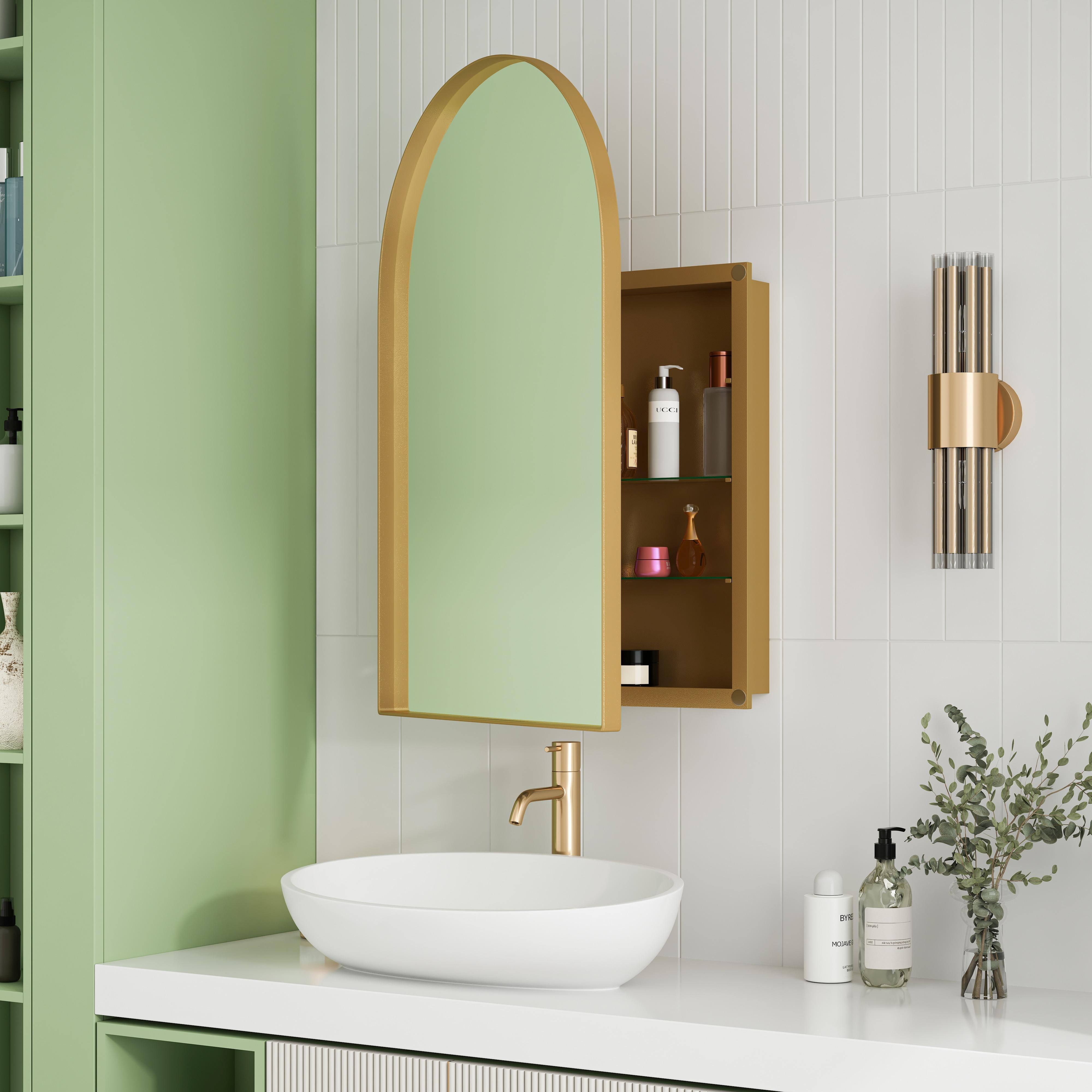 Badezimmer mit goldgerahmtem Spiegel, Waschbecken und Wandleuchte. Hellgrüner Schrank und weiße Fliesen.