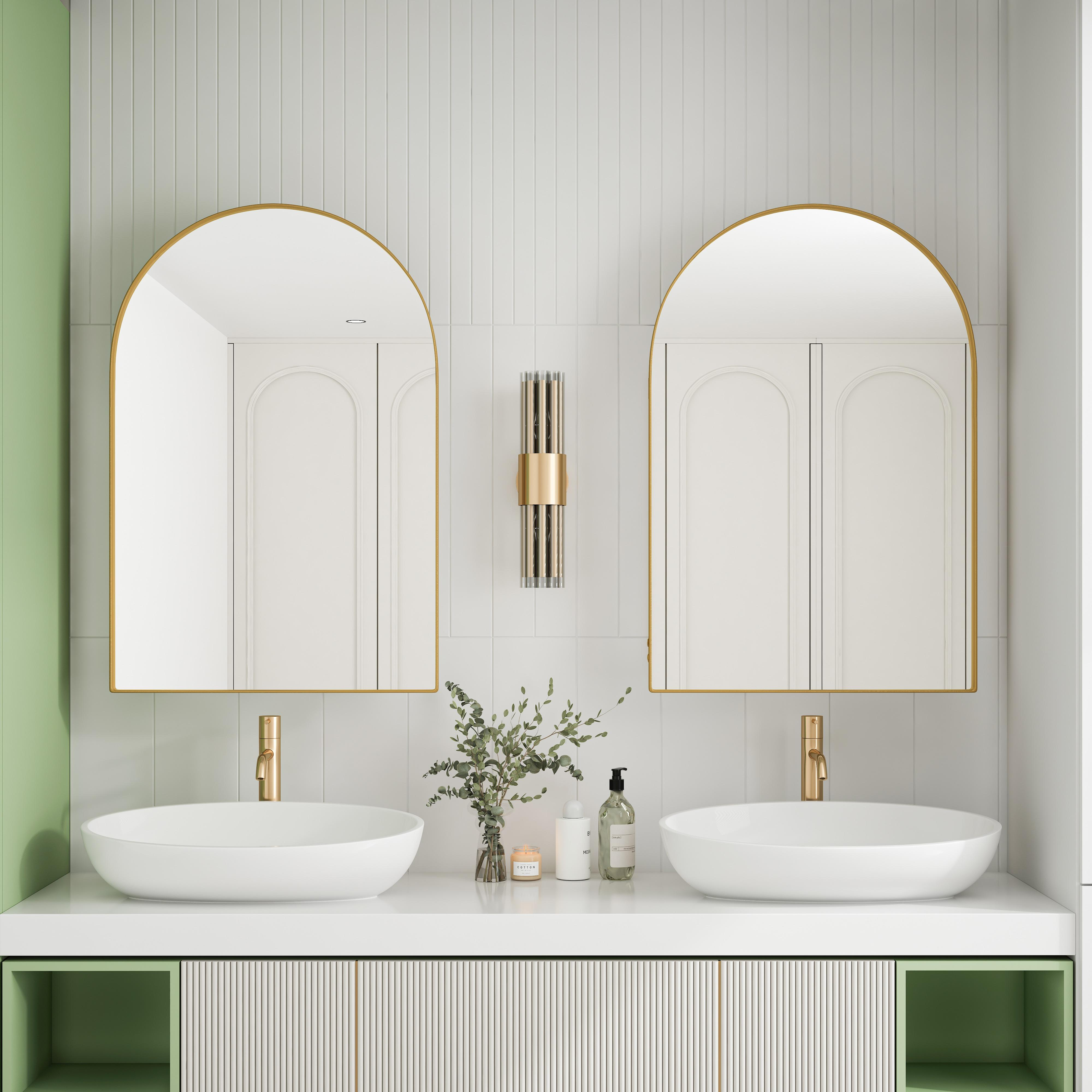 Badezimmer mit zwei Waschbecken, Spiegeln und goldenen Akzenten. Grün-weißes Farbschema. Modernes Design.