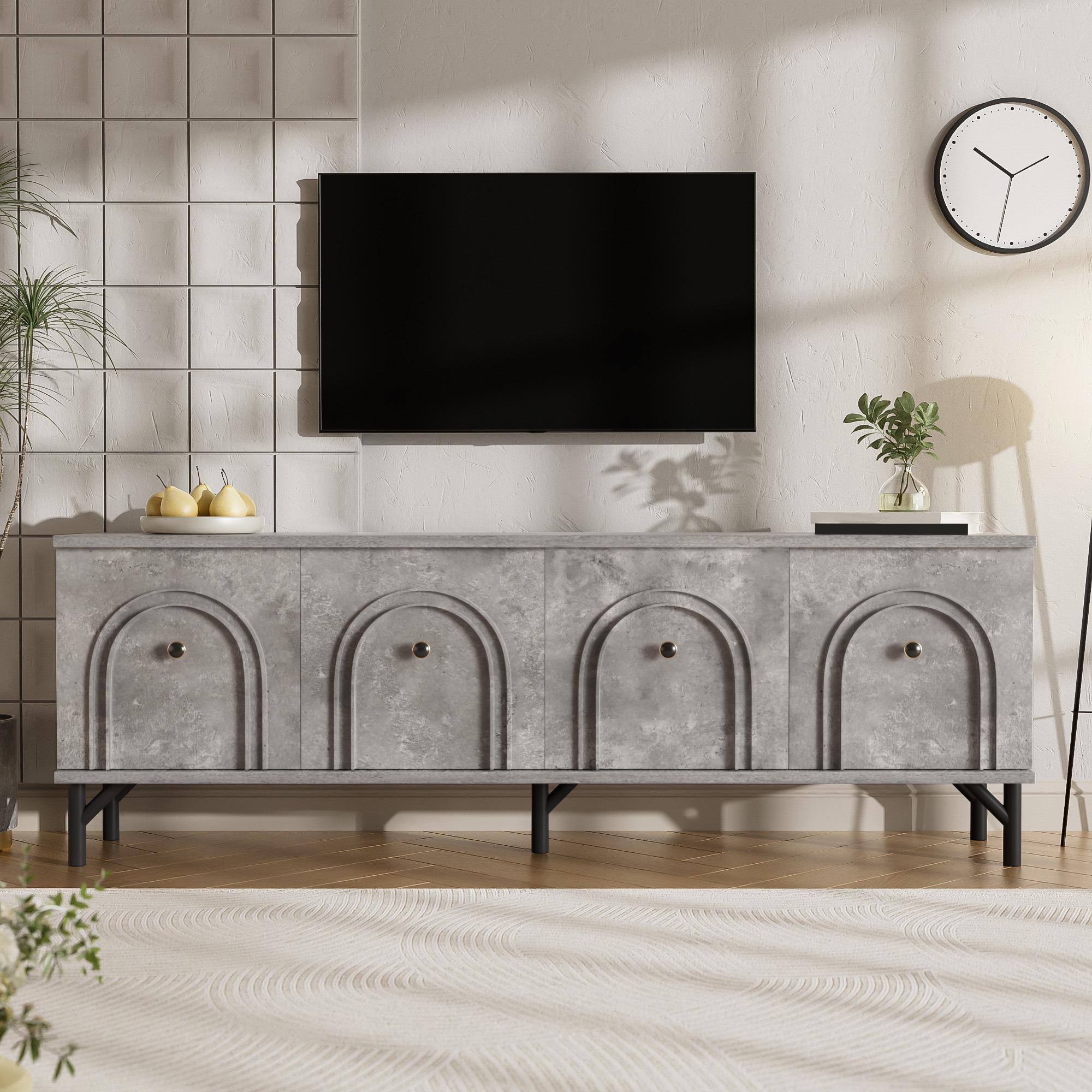 Ein modernes Wohnzimmer mit TV über einem grauen Schrank. Uhr und Pflanzen schmücken die Wand. Holzboden und ein Teppich.