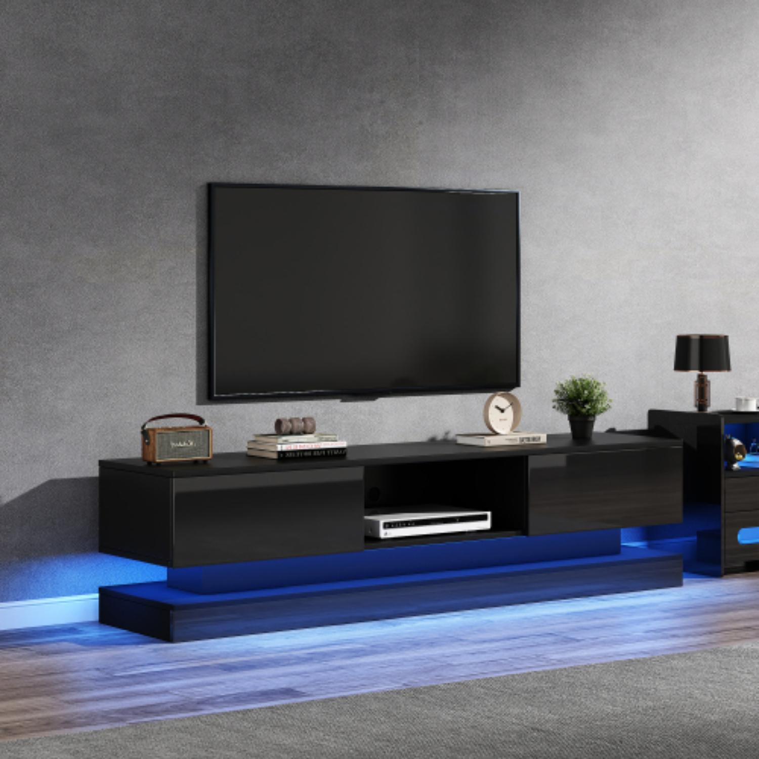 Ein moderner schwarzer TV-Ständer mit montiertem Fernseher. Er hat blaue LED-Beleuchtung. Ein Radio, eine Uhr und eine Lampe sind ebenfalls sichtbar.