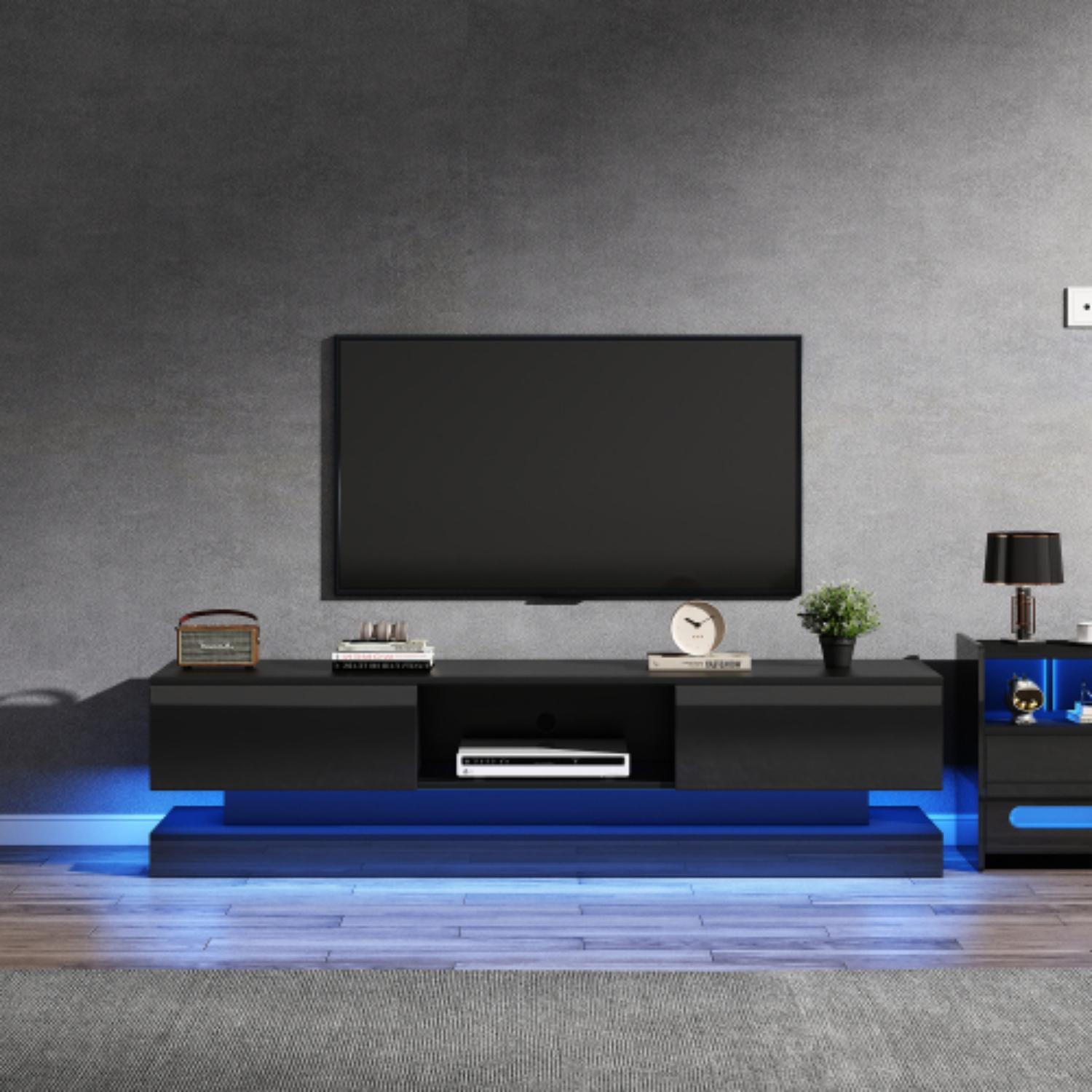 Schwarzer TV-Ständer mit TV an grauer Wand. Uhr, Pflanze und Lampe stehen darauf. Der Ständer hat blaue Lichter.