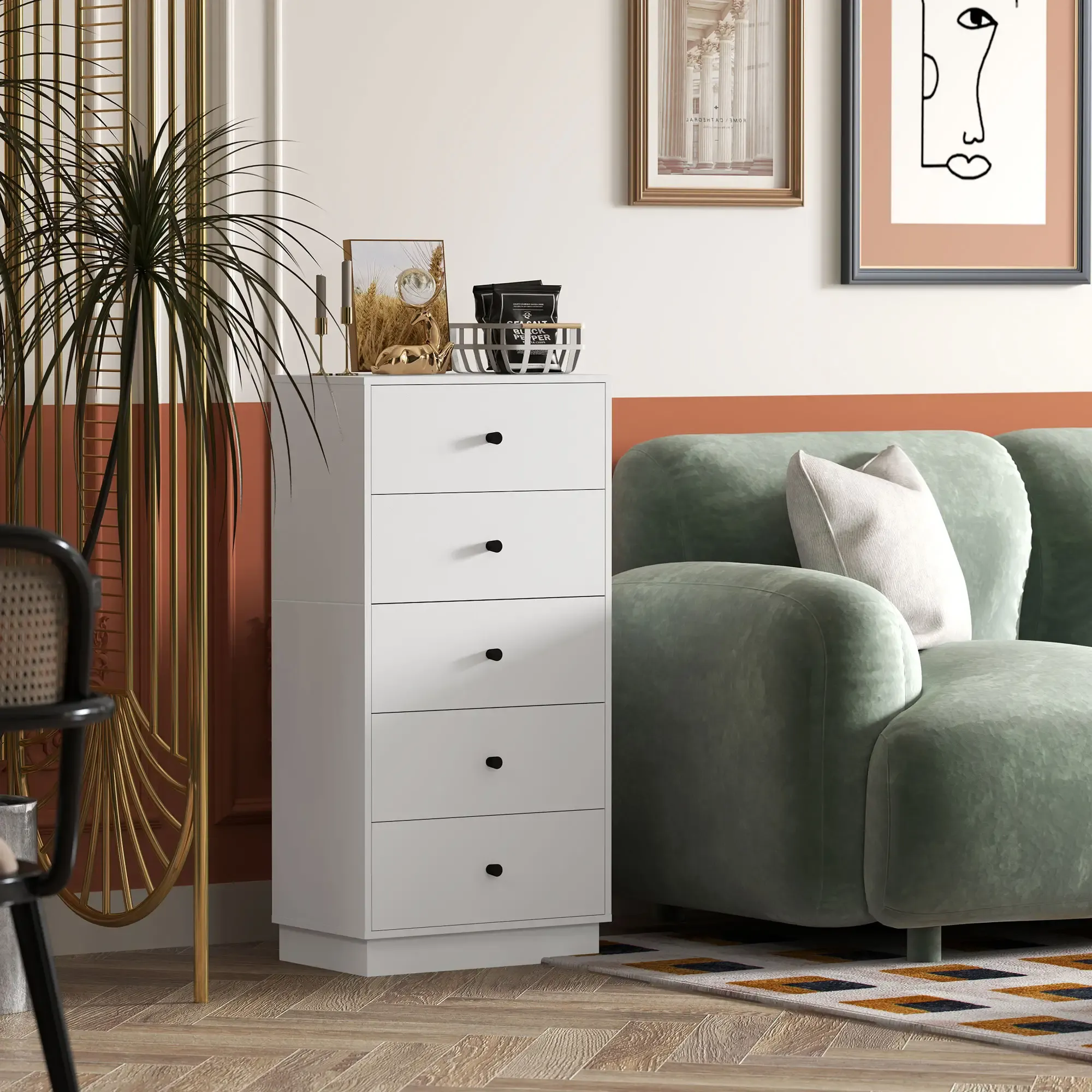 Weiße Kommode mit schwarzen Knöpfen, grünes Sofa mit weißem Kissen und Kunst an der Wand.