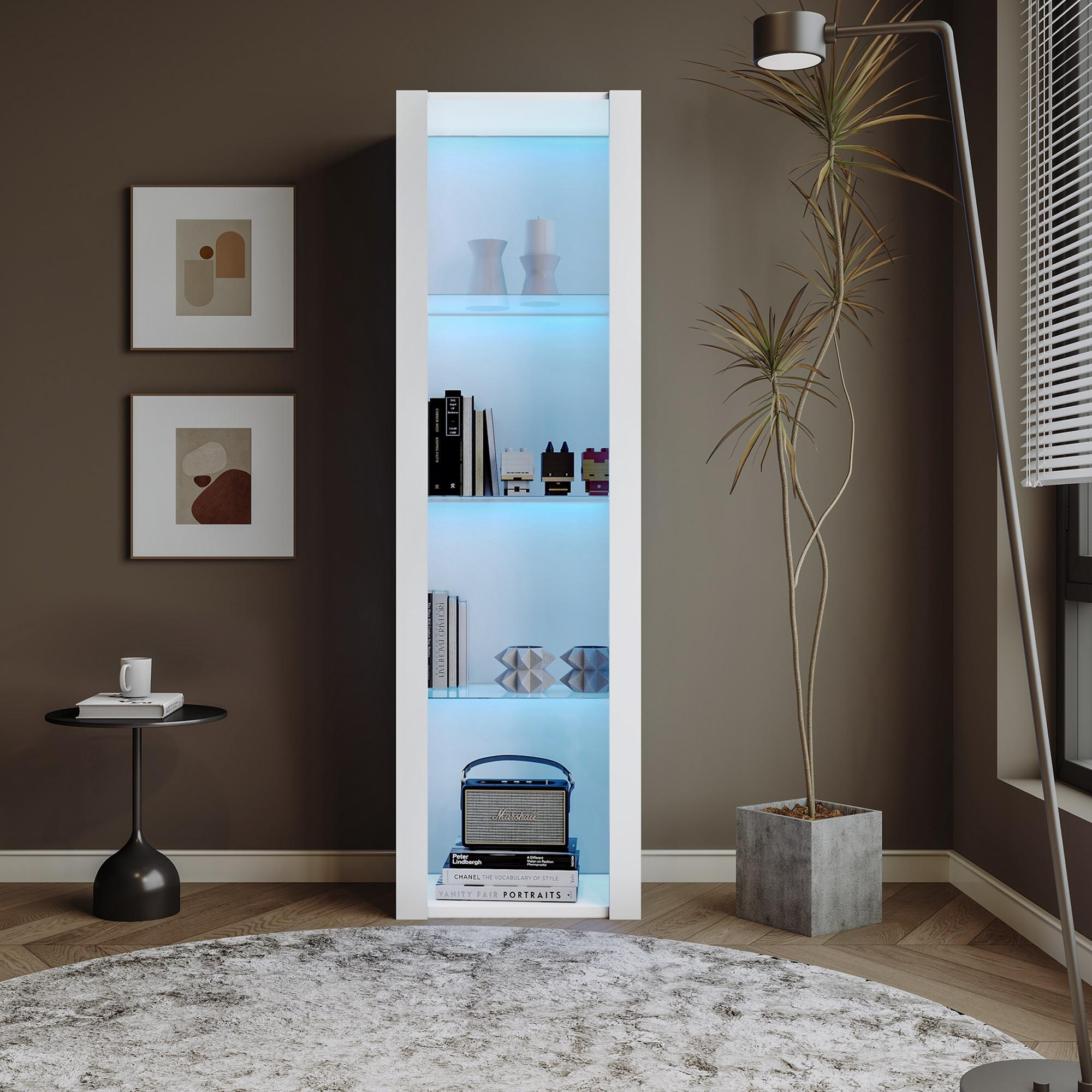 Ein weißer Schrank mit beleuchteten Regalen zeigt Bücher und Dekoration. Eine Pflanze, eine Lampe und ein Teppich sind ebenfalls im Raum zu sehen.