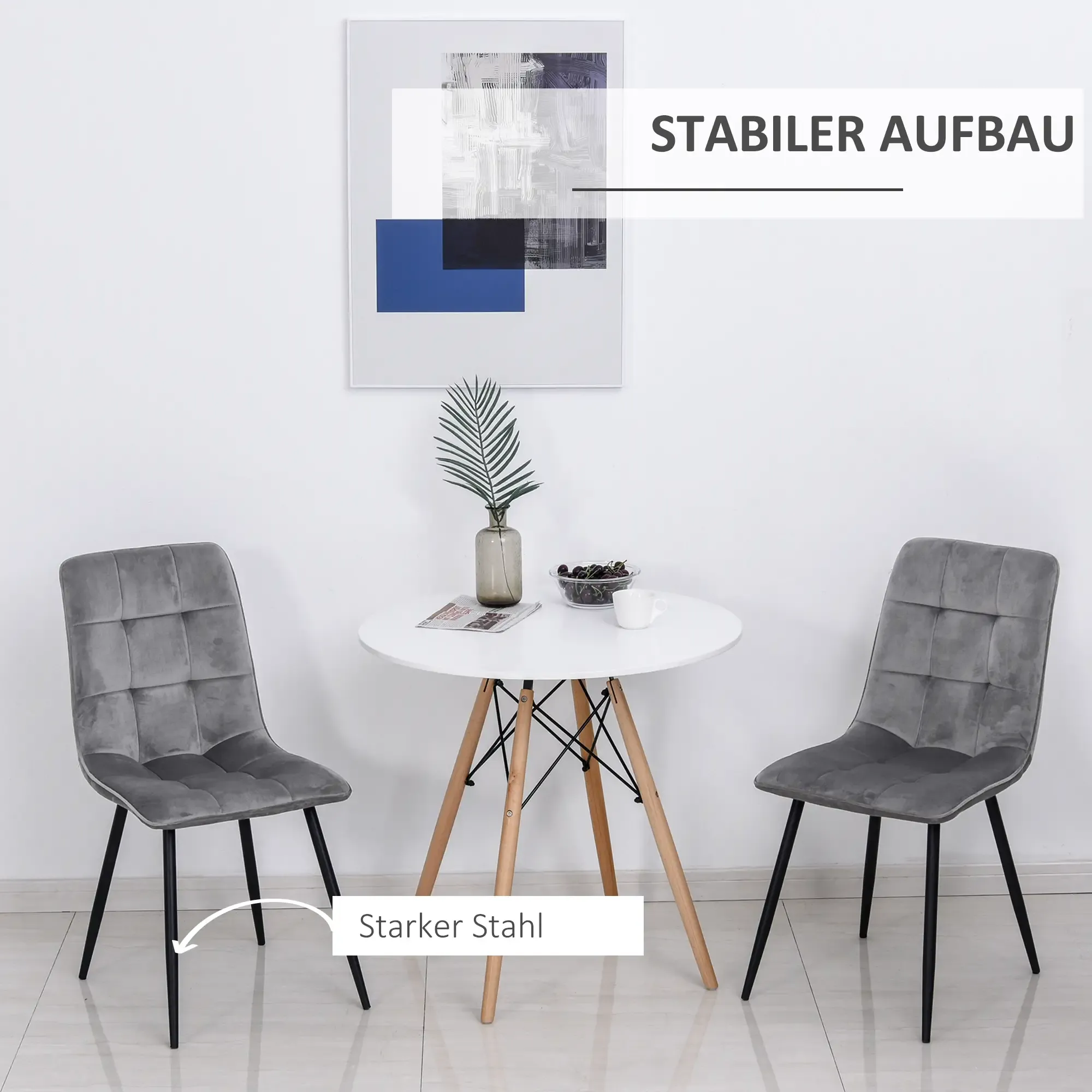 Zwei graue Stühle mit schwarzen Beinen flankieren einen kleinen Tisch. Ein Bild hängt darüber. Der Text lautet 'STABILER AUFBAU'.