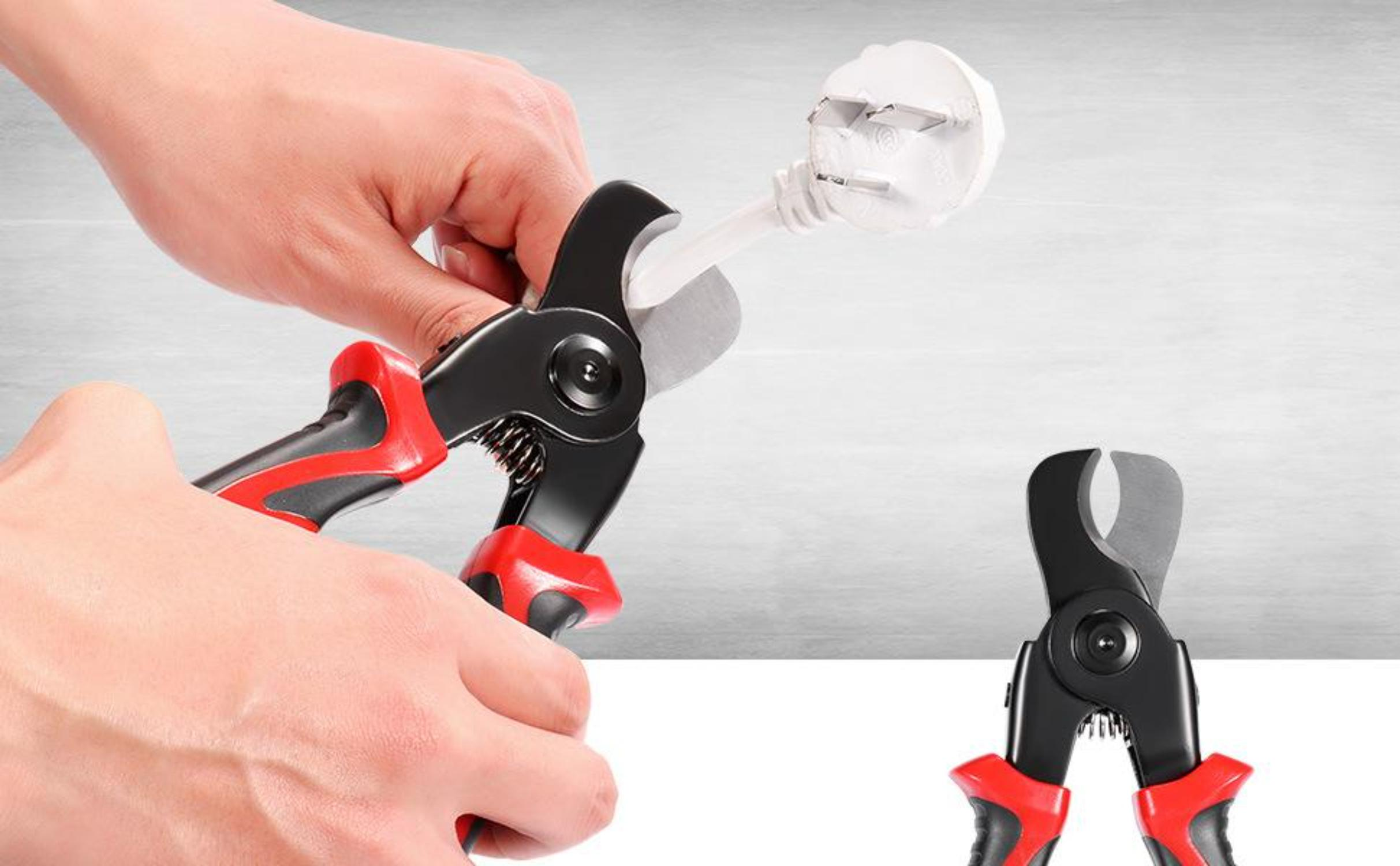Eine Hand benutzt eine rot-schwarze Schere, um einen weißen Stecker von einem weißen Kabel abzuschneiden. Eine andere Schere liegt auf einer weißen Oberfläche.