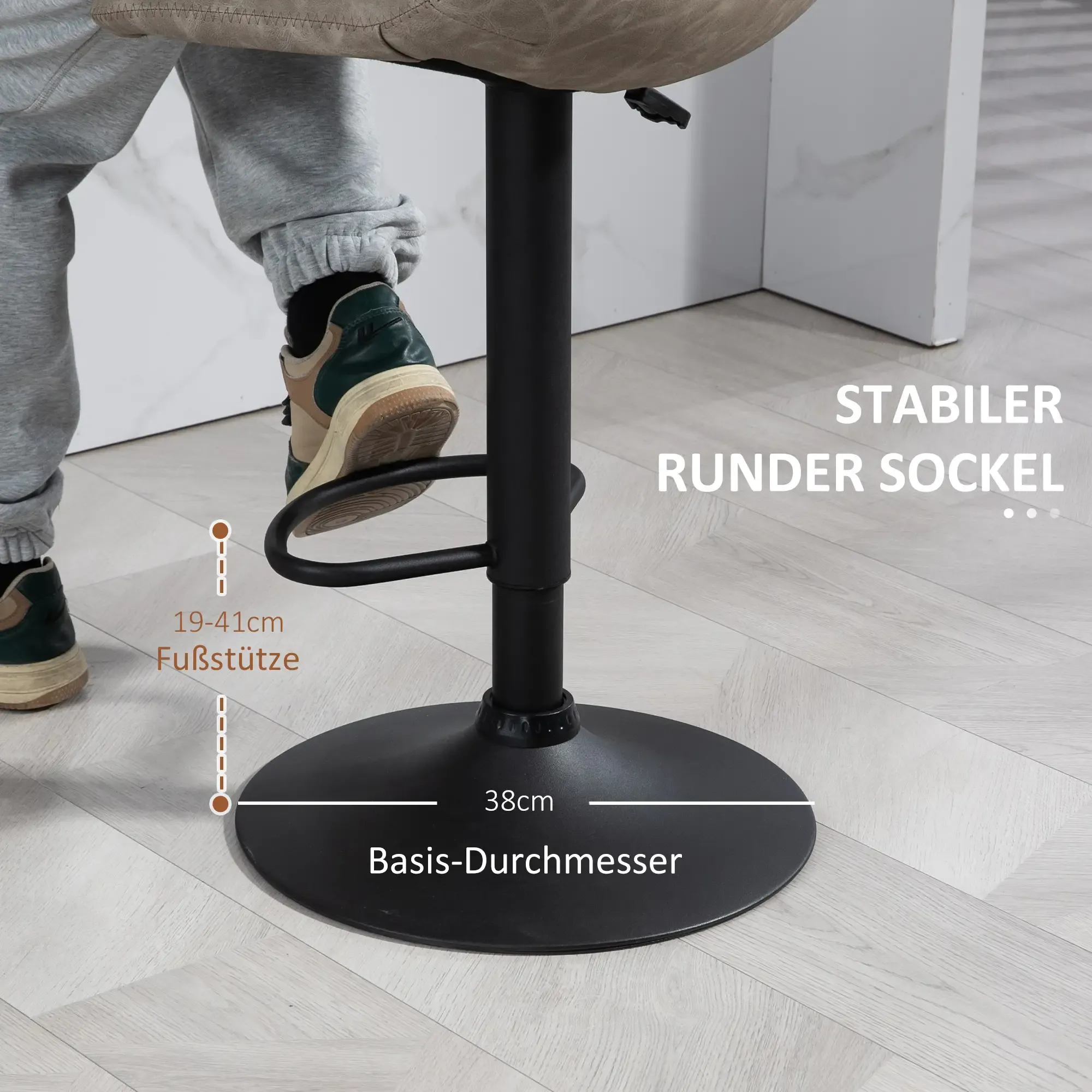 Eine Person sitzt auf einem schwarzen Barhocker. Der Hocker hat einen runden Fuß und eine Fußstütze. Text: 'STABILER RUNDER SOCKEL'.