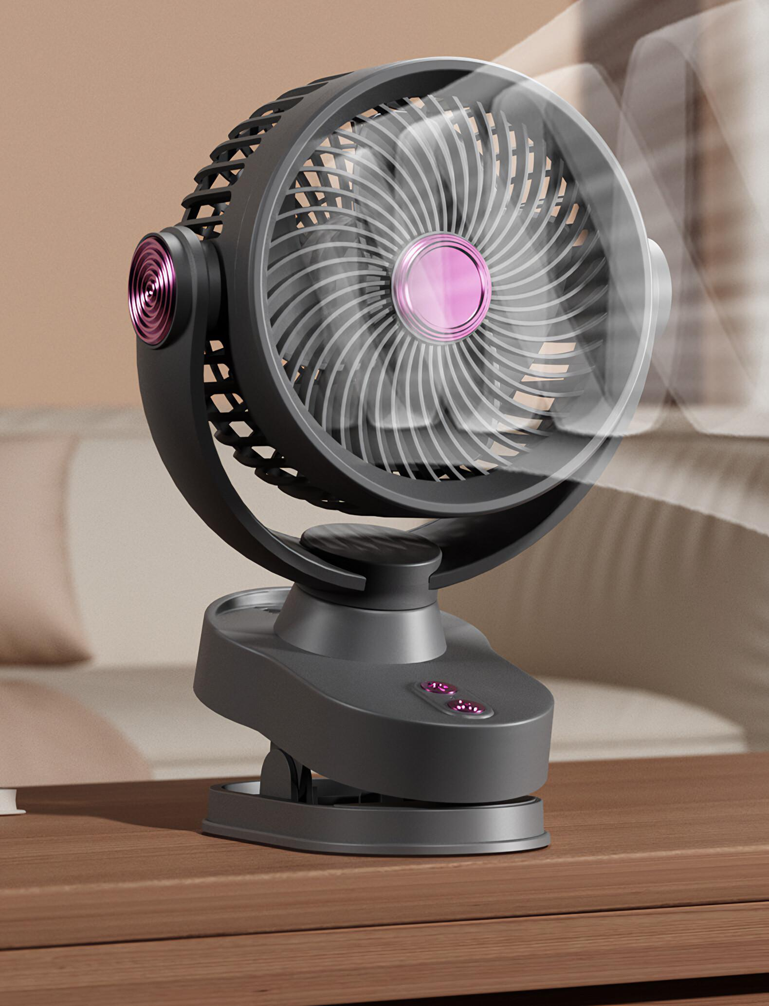 Ein dunkelgrauer Tischventilator mit rosa Akzenten steht auf einer Holzoberfläche. Der Ventilator ist an.