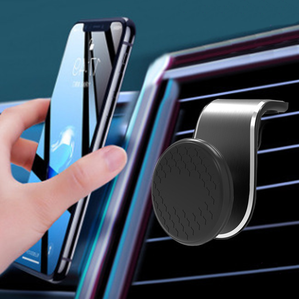 Eine Hand hält ein Smartphone in der Nähe einer Lüftungsöffnung im Auto mit einem magnetischen Telefonhalter. Der Bildschirm ist an.