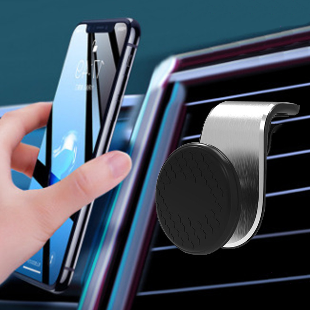 Eine Hand hält ein Telefon in der Nähe einer Lüftungshalterung für das Auto. Der Bildschirm des Telefons ist sichtbar, die Halterung ist silber und schwarz.
