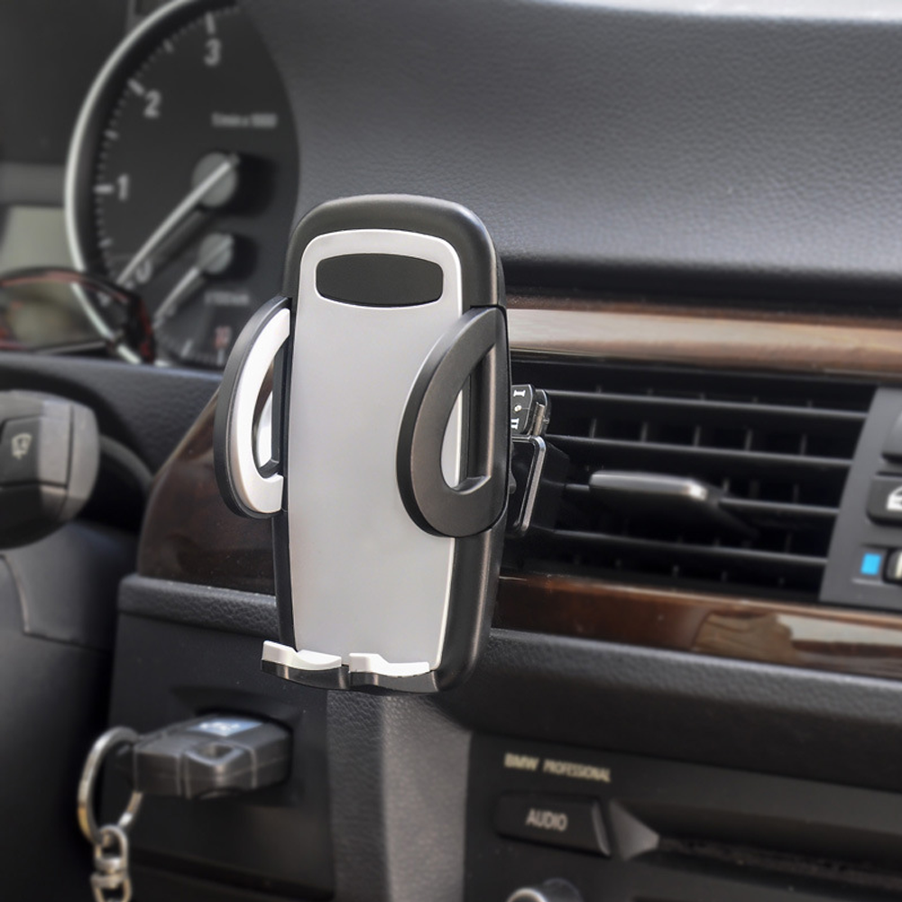 Ein Autotelefonhalter ist am Armaturenbrett eines Autos montiert. Der Halter ist grau und schwarz. Ein Schlüssel steckt in der Zündung.