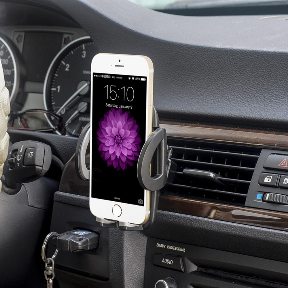 Ein Smartphone mit Uhrzeit und Datum ist im Auto montiert. Auf dem Bildschirm ist eine lila Blume zu sehen. Das Armaturenbrett ist sichtbar.