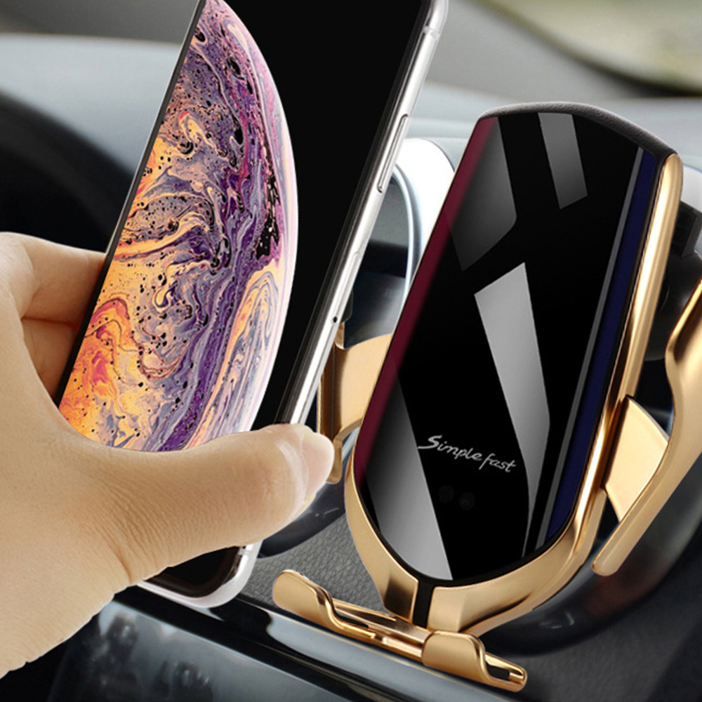 Eine Hand legt ein Smartphone auf eine Autotelefonhalterung. Die Halterung ist gold und schwarz, das Telefon silber und schwarz.