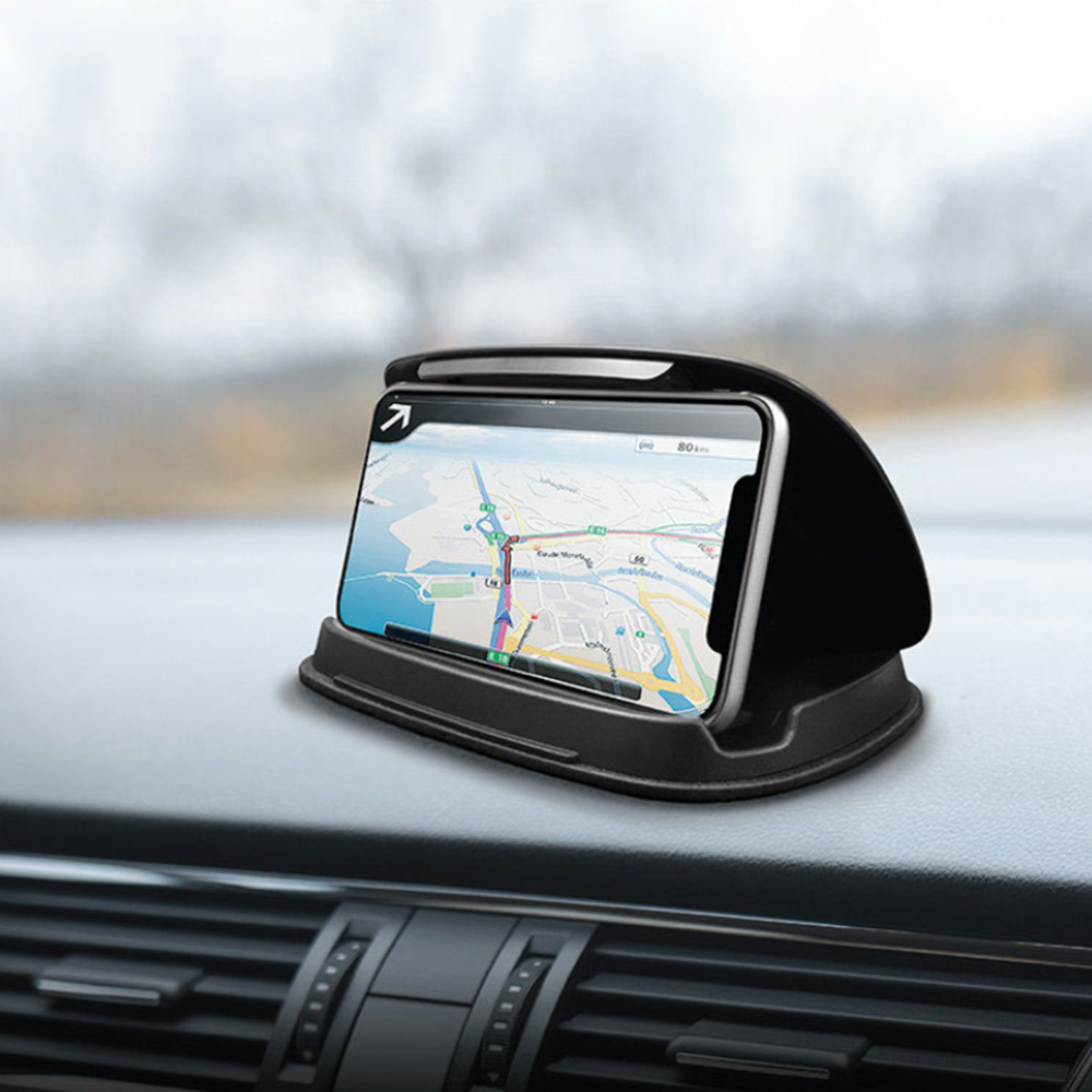 Ein Telefon mit Navigationskarte in einer schwarzen Halterung auf dem Armaturenbrett eines Autos. Der Hintergrund ist verschwommen.