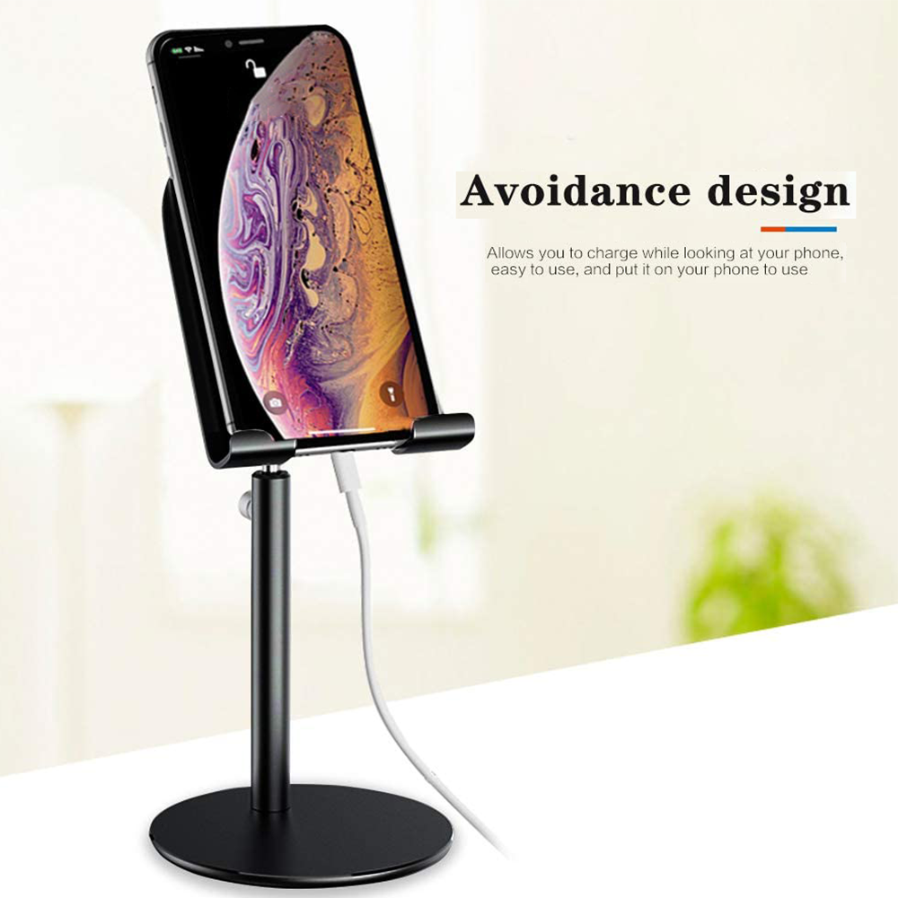 Ein schwarzes Telefon auf einem Ständer wird geladen. Text: 'Avoidance design'. Weißes Kabel. Hintergrund unscharf.