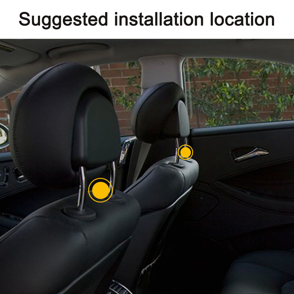 Innenraumansicht eines Autos mit zwei schwarzen Kopfstützen und gelben Kreisen, die die empfohlenen Installationspunkte anzeigen. Im Hintergrund ist eine Ziegelmauer zu sehen.