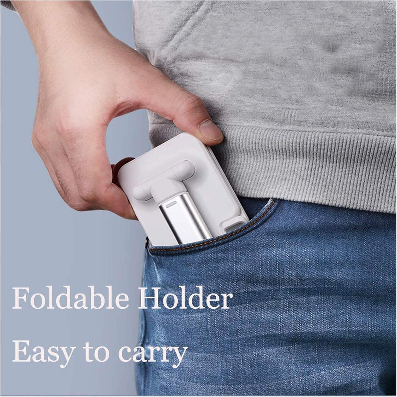 Eine Hand, die einen weißen, zusammenklappbaren Telefonhalter in eine Jeanstasche steckt. Grauer Hoodie im Hintergrund. Text: Zusammenklappbarer Halter Einfach zu tragen.