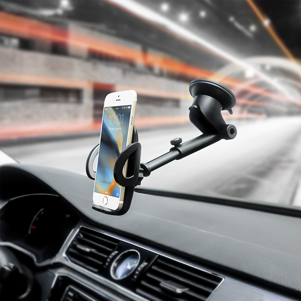 Ein Telefon in einer Autohalterung auf dem Armaturenbrett. Das Telefon zeigt die Uhrzeit an. Der Hintergrund zeigt die Straße und Bewegungsunschärfe.
