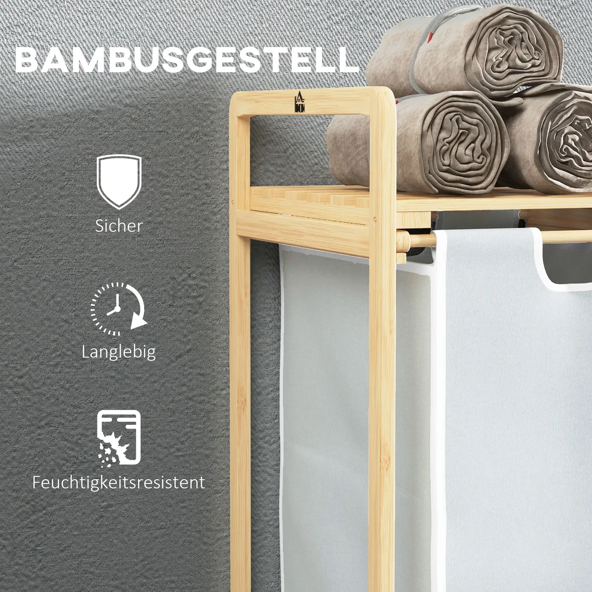 Ein Bambusregal mit gerollten beigefarbenen Handtüchern. Darunter hängt ein weißer Wäschebeutel. Der Hintergrund ist eine strukturierte graue Wand.