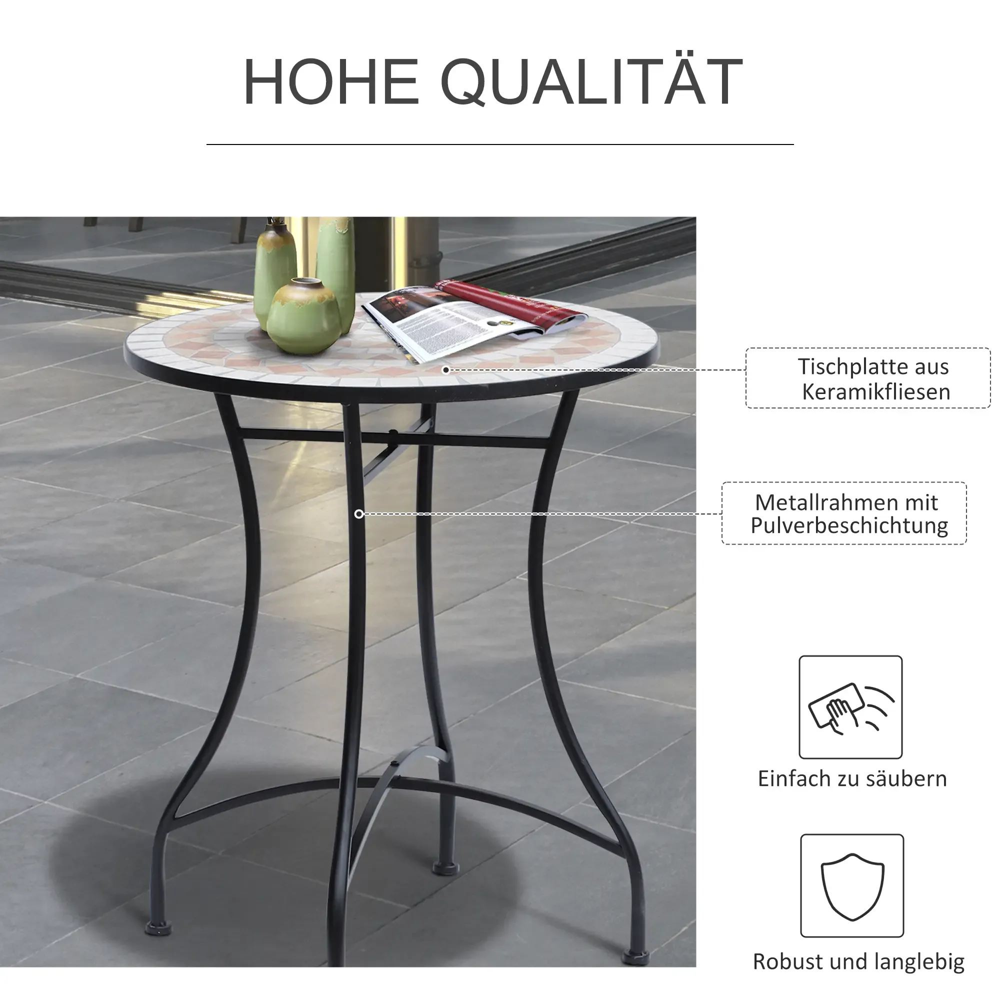 Ein runder Tisch mit Mosaikoberfläche. Er hat ein schwarzes Metallgestell. Vasen und eine Zeitschrift liegen auf dem Tisch.