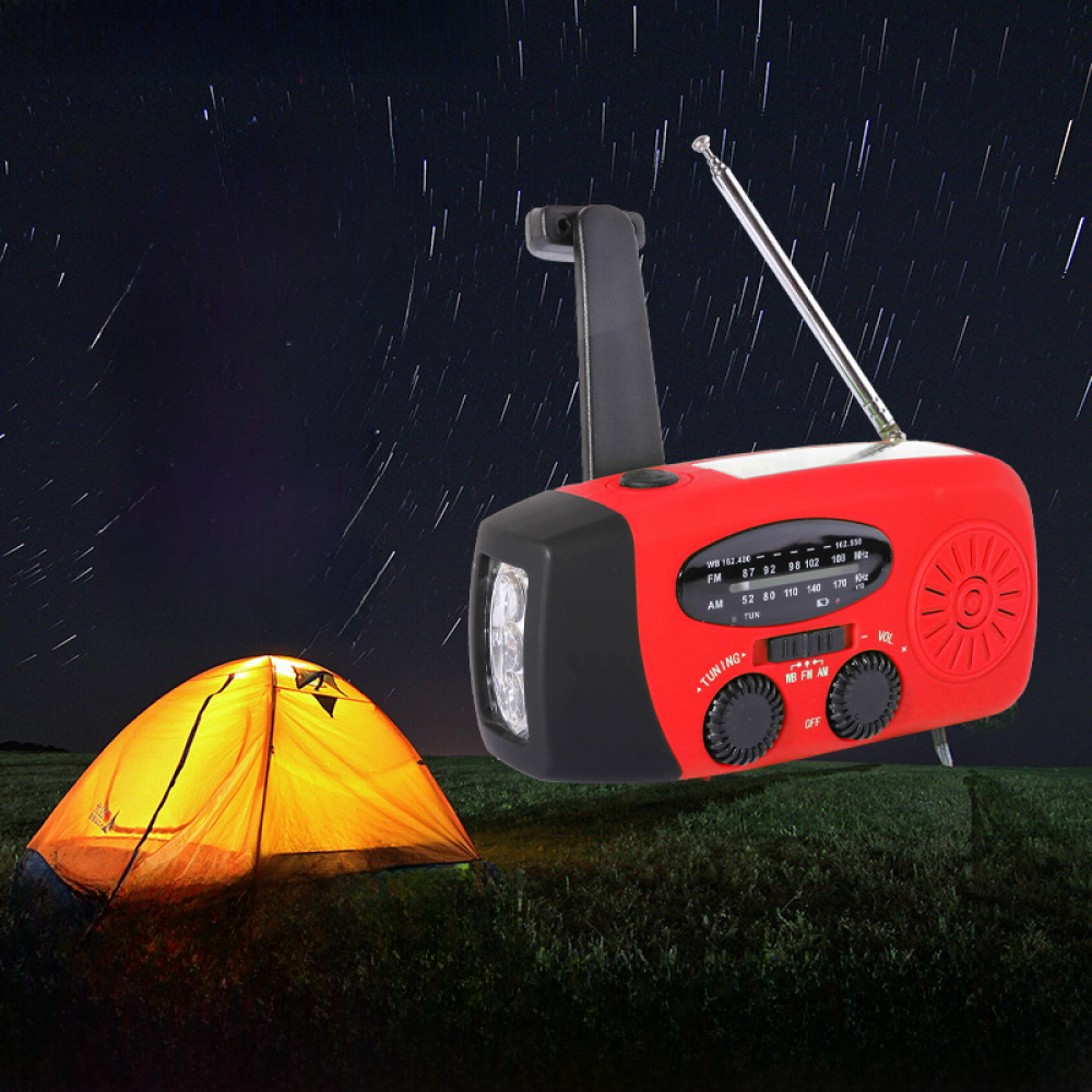 Ein rotes Radio mit Taschenlampe und ein Zelt in einer Nachtszene. Der Himmel hat weiße Sternenspuren. Das Zelt ist von innen beleuchtet.