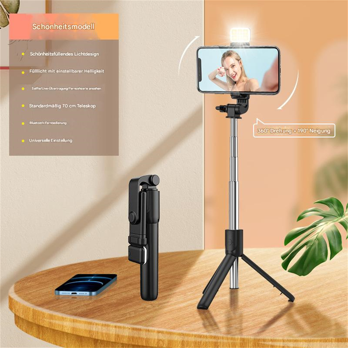 Ein Smartphone auf einem Stativ macht ein Selfie. Oben ist ein Licht. Ein Selfie-Stick und ein Telefon liegen auf dem Tisch.