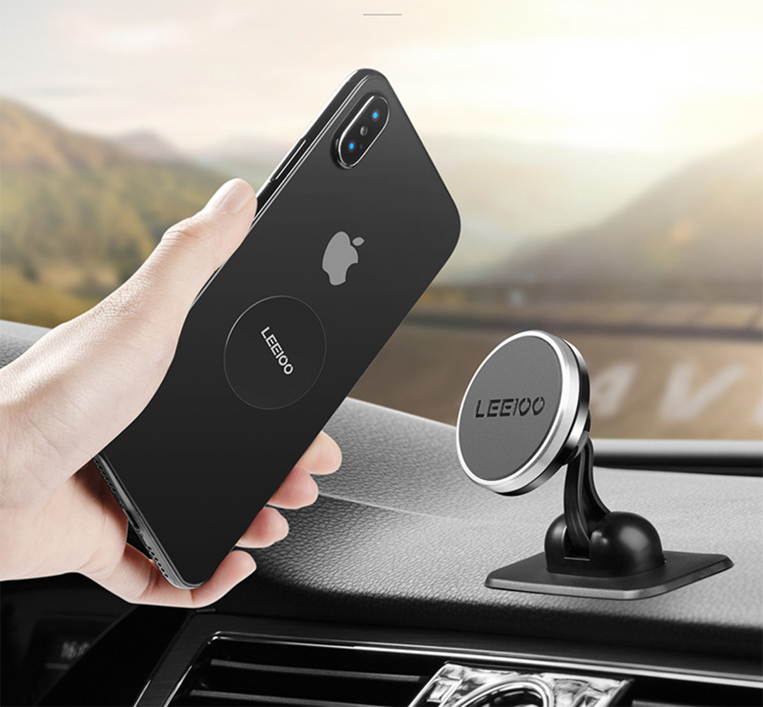 Eine Hand hält ein schwarzes iPhone mit einem LEEIOO-Aufkleber. Auf dem Armaturenbrett befindet sich eine Autotelefonhalterung.