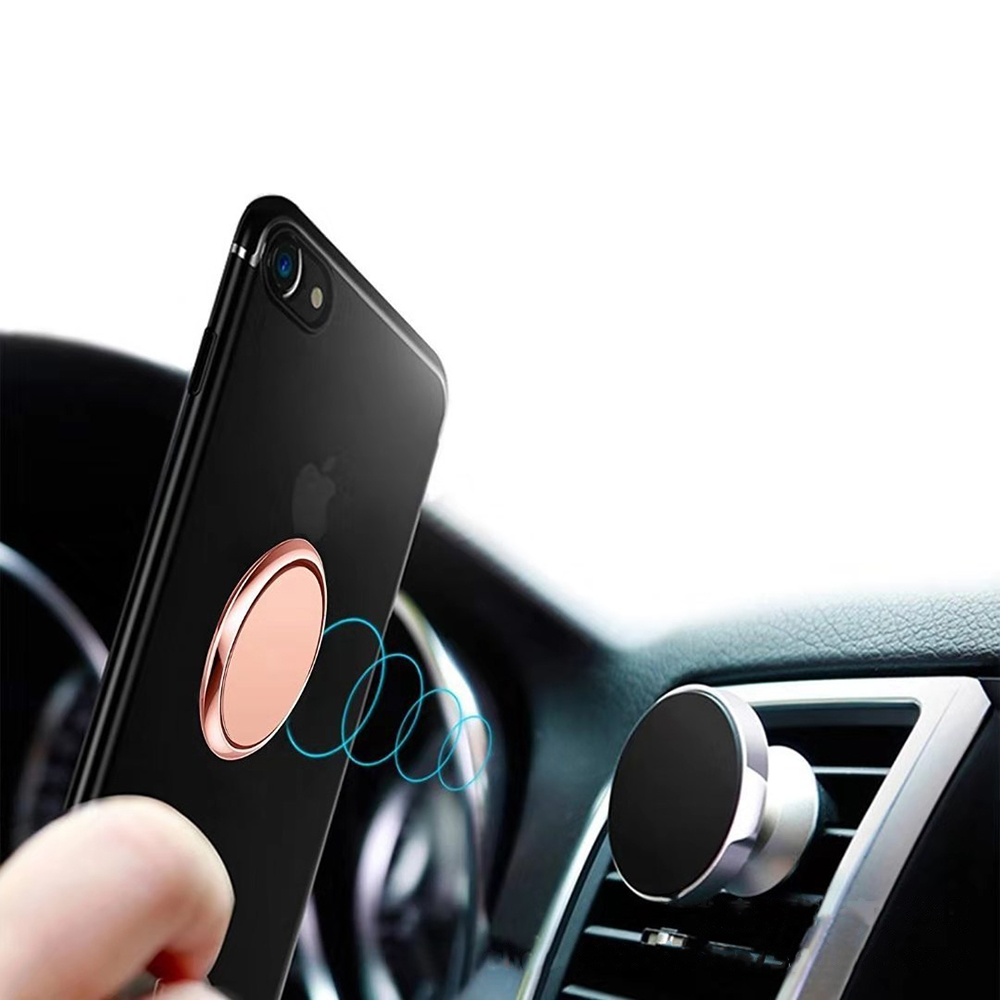 Schwarzes Telefon mit roségoldenem Ring ist an einer magnetischen Autohalterung befestigt. Die Halterung ist silber und schwarz. Innenraum sichtbar.