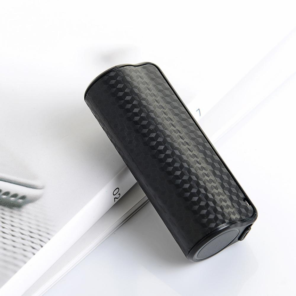 Ein schwarzes, gemustertes Vape-Gerät liegt auf einer weißen Oberfläche mit einem Magazin. Das Gerät hat eine zylindrische Form und eine strukturierte Oberfläche.
