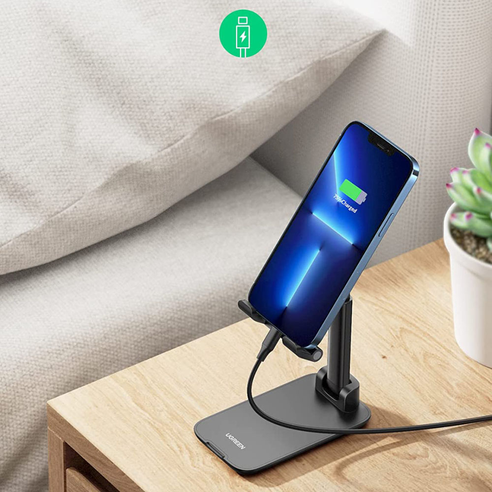 Ein Smartphone wird auf einem Ständer geladen. Der Bildschirm zeigt 75 % geladen. Ein grünes Ladesymbol im Hintergrund.