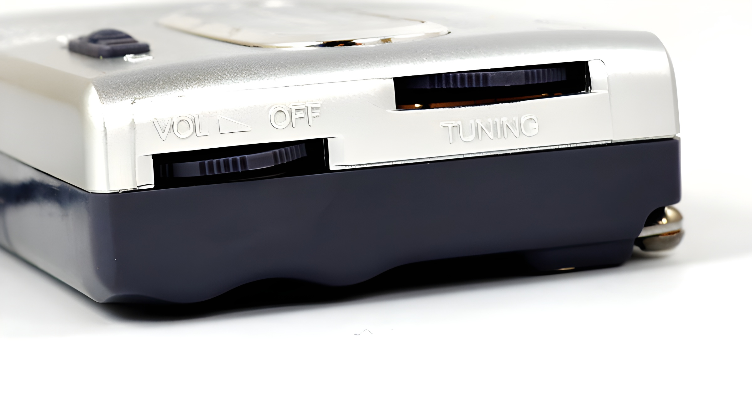 Nahaufnahme eines silber-schwarzen Radios. Sichtbar sind Lautstärke- und Abstimmräder, die Worte 'VOL OFF' und 'TUNING'.
