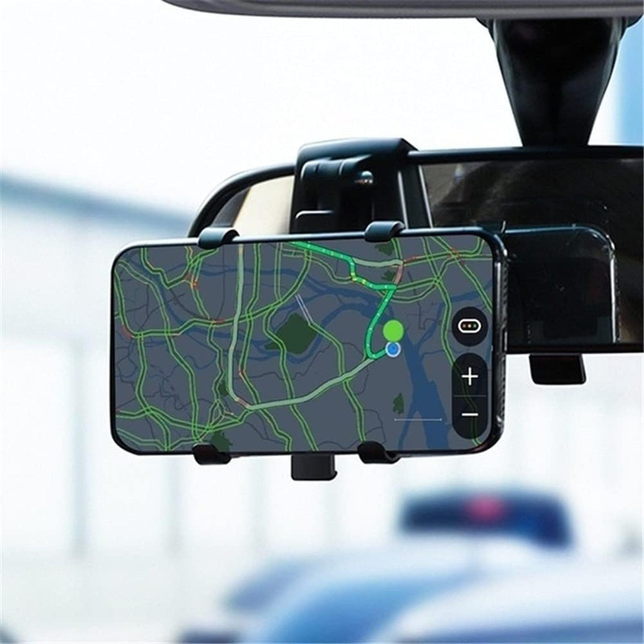 Ein Smartphone mit Navigations-App ist am Rückspiegel eines Autos befestigt. Der Bildschirm zeigt eine Karte.