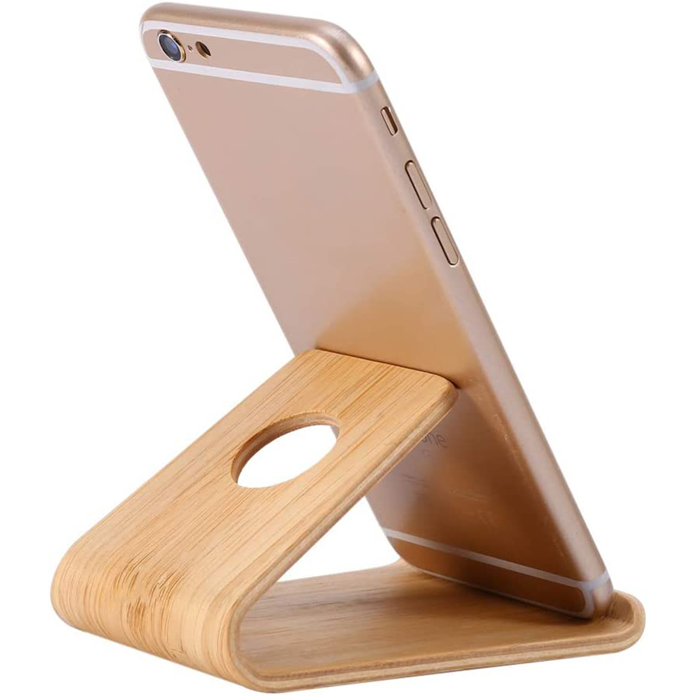 Ein goldenes Smartphone steht auf einem Holzständer. Der Ständer besteht aus hellfarbenem Holz mit geschwungenem Design. Das Telefon ist angewinkelt.