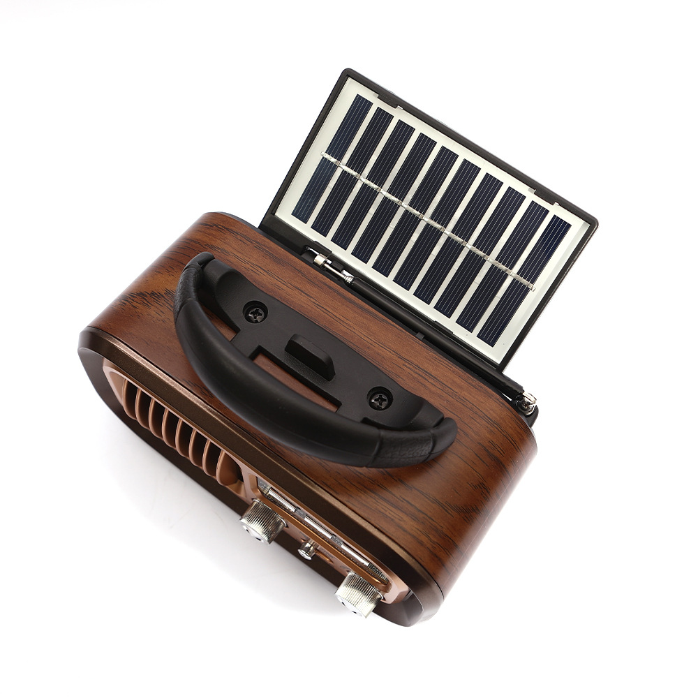 Ein Holzradio mit schwarzem Griff und Solarpanel oben, vor weißem Hintergrund. Zwei Knöpfe sind vorne sichtbar.