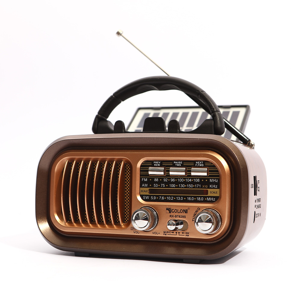 Ein braunes und goldenes Retro-Radio mit Griff, Antenne und Solarpanel. Es hat Knöpfe und Regler vor weißem Hintergrund.