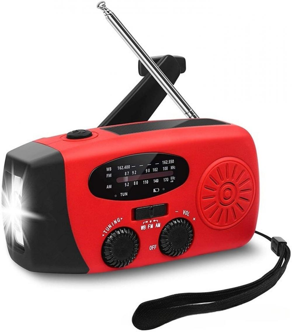 Ein rotes Notfallradio mit schwarzer Antenne, Taschenlampe und Knöpfen. Es hat eine Handschlaufe. Das Radio steht vor weißem Hintergrund.