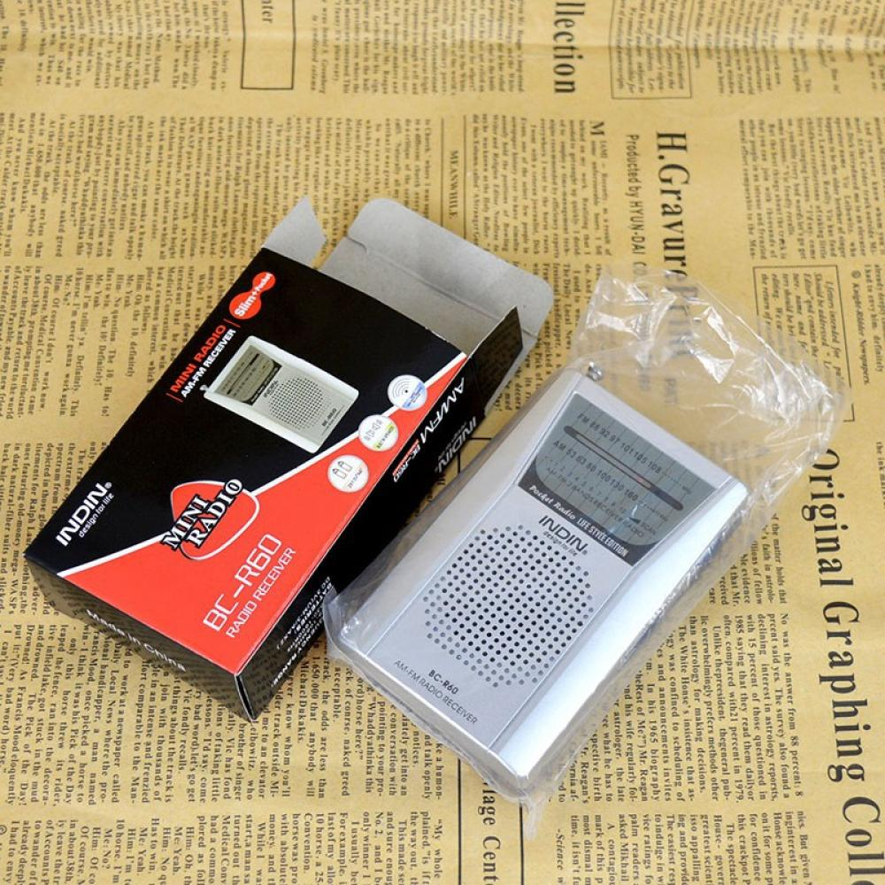 Radio und Verpackung auf Zeitungshintergrund. Radio hat Bildschirm und Knöpfe. Verpackung ist schwarz und rot.