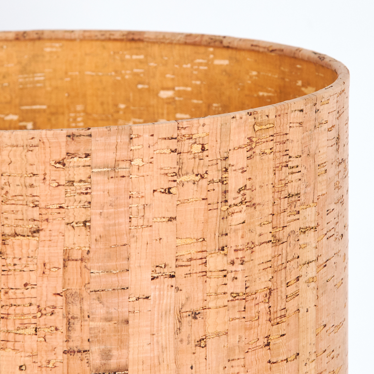 Nahaufnahme eines zylindrischen Lampenschirms aus Kork. Die Oberfläche hat eine strukturierte, natürliche Holzmaserung mit hellen und dunklen Brauntönen.